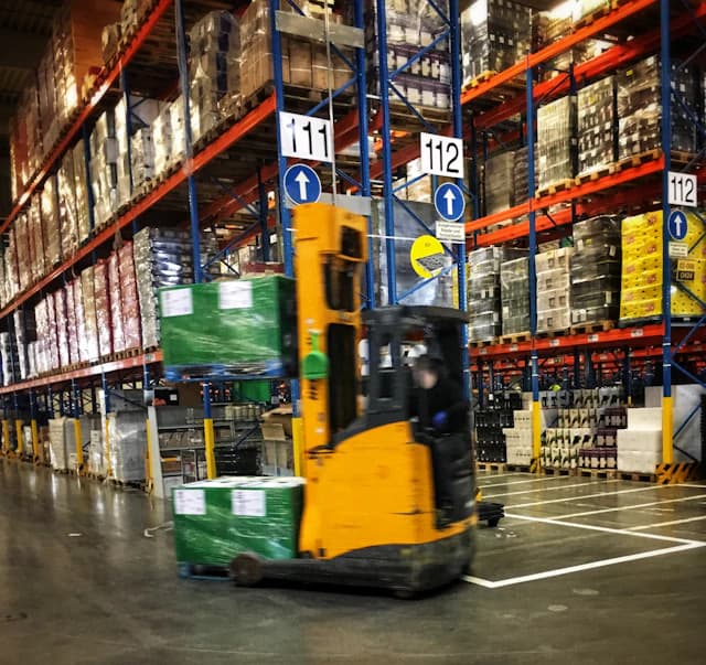 Forklift moving palletised cargo through a secure warehouse facility